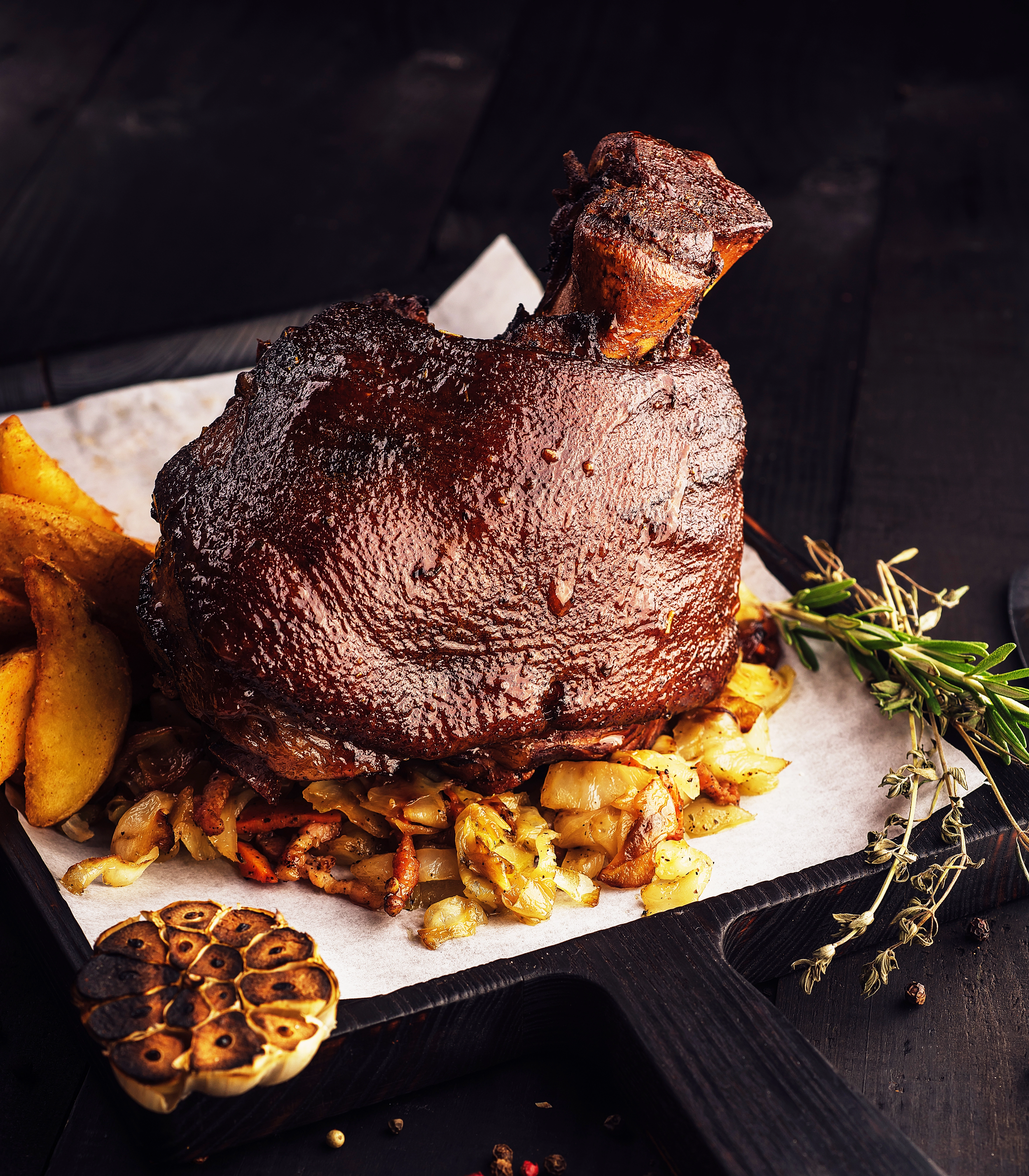 Roasted pork knuckle Eisbein served on a wooden cutting board at Bubbles restaurant Phnom Penh